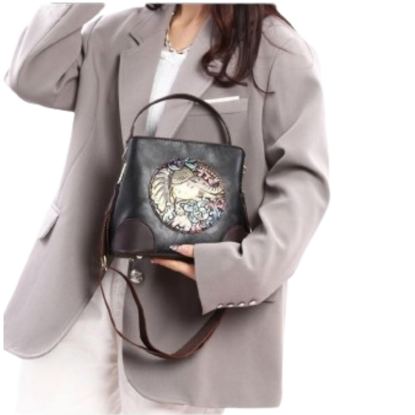 Person holding a black handbag with decorative elements against a white background