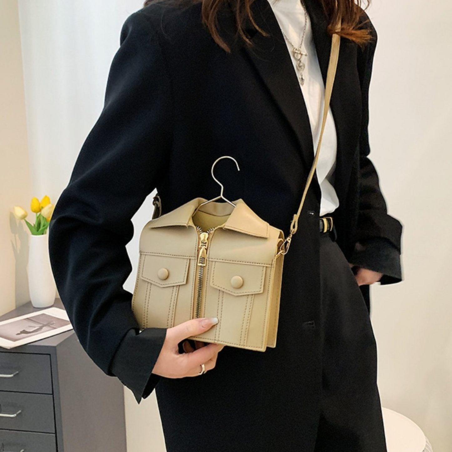 a beige sling bag with a hanger