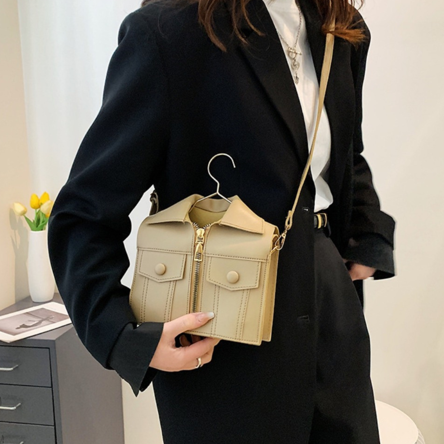 a beige sling bag with a hanger